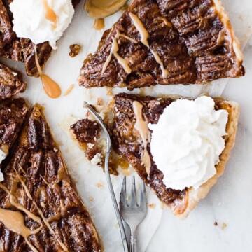 two slices of pecan pie with caramel drizzle and whip cream