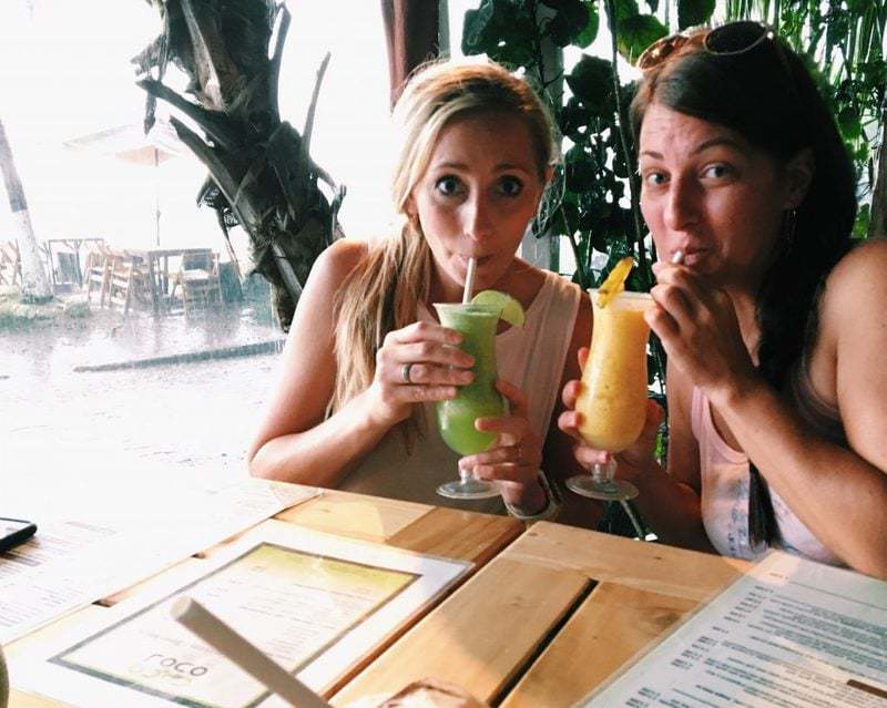 two women drinking limeade drink 