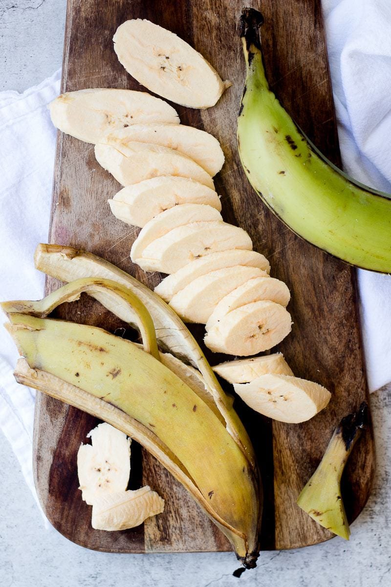 Chopped Plantains and their skins on a wooden board