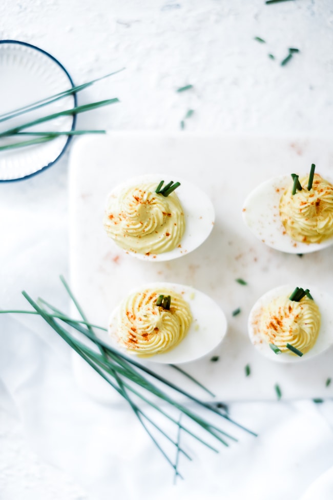 Deviled eggs on a marble serving tray.