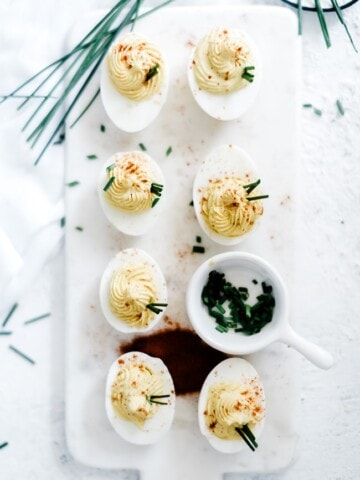 The best deviled eggs recipe on a marble cutting board.