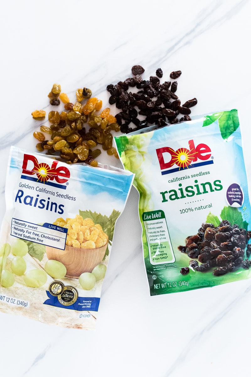 Two packets of Dole raisins on a white surface used to make Homemade Oatmeal Raisin Granola Bars