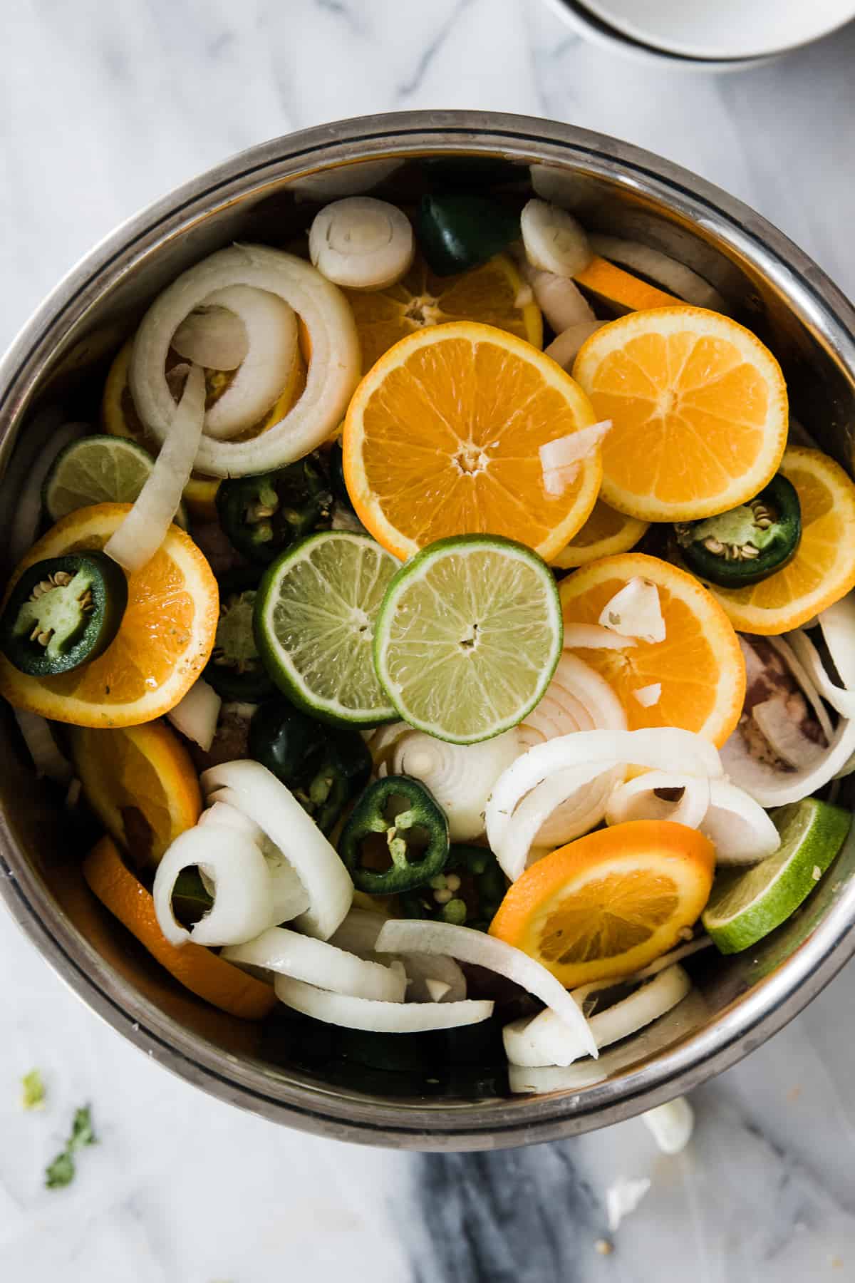 instant pot inner pot with pork and oranges and onions inside. 