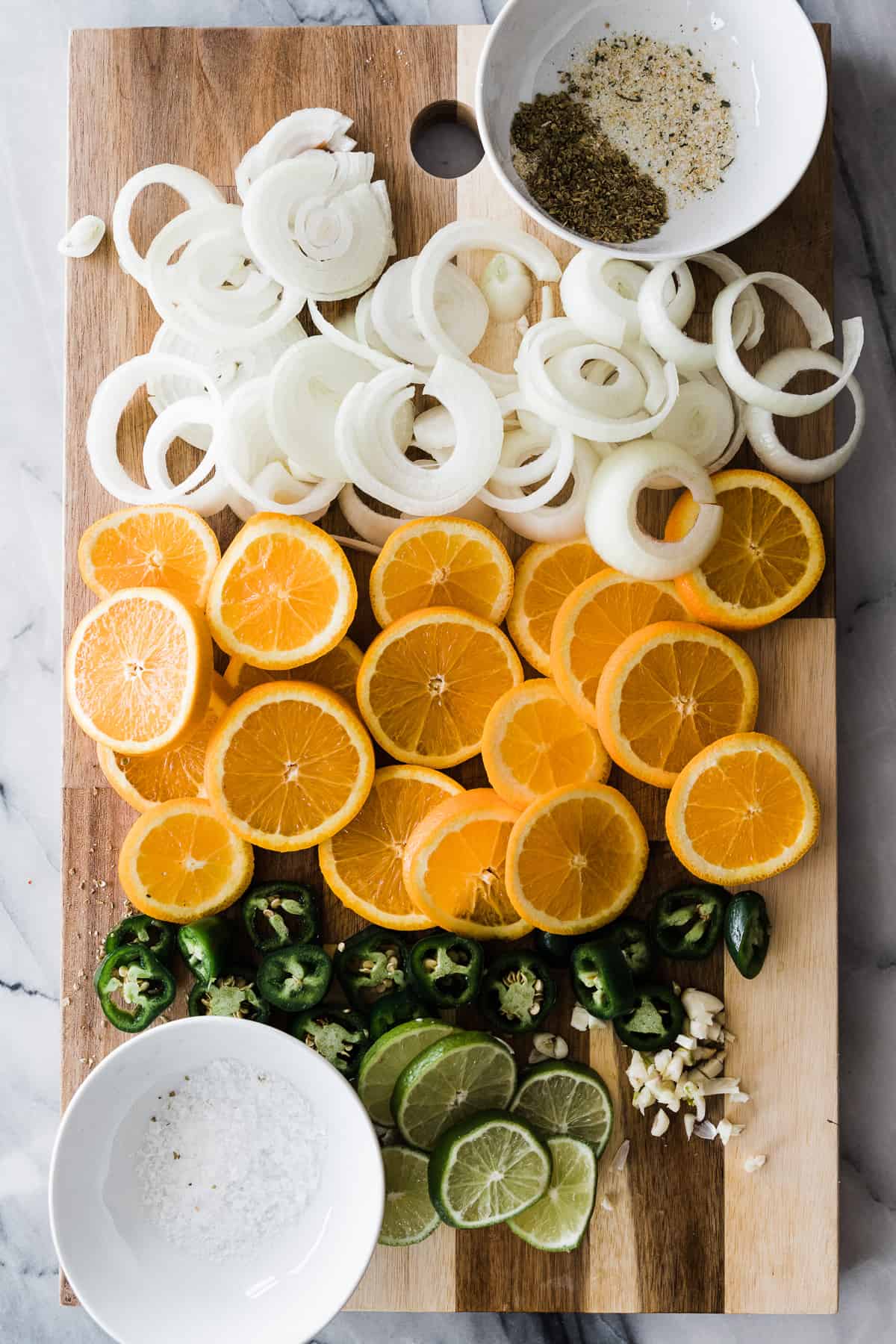 onion, oranges, jalapeno, limes on cutting board