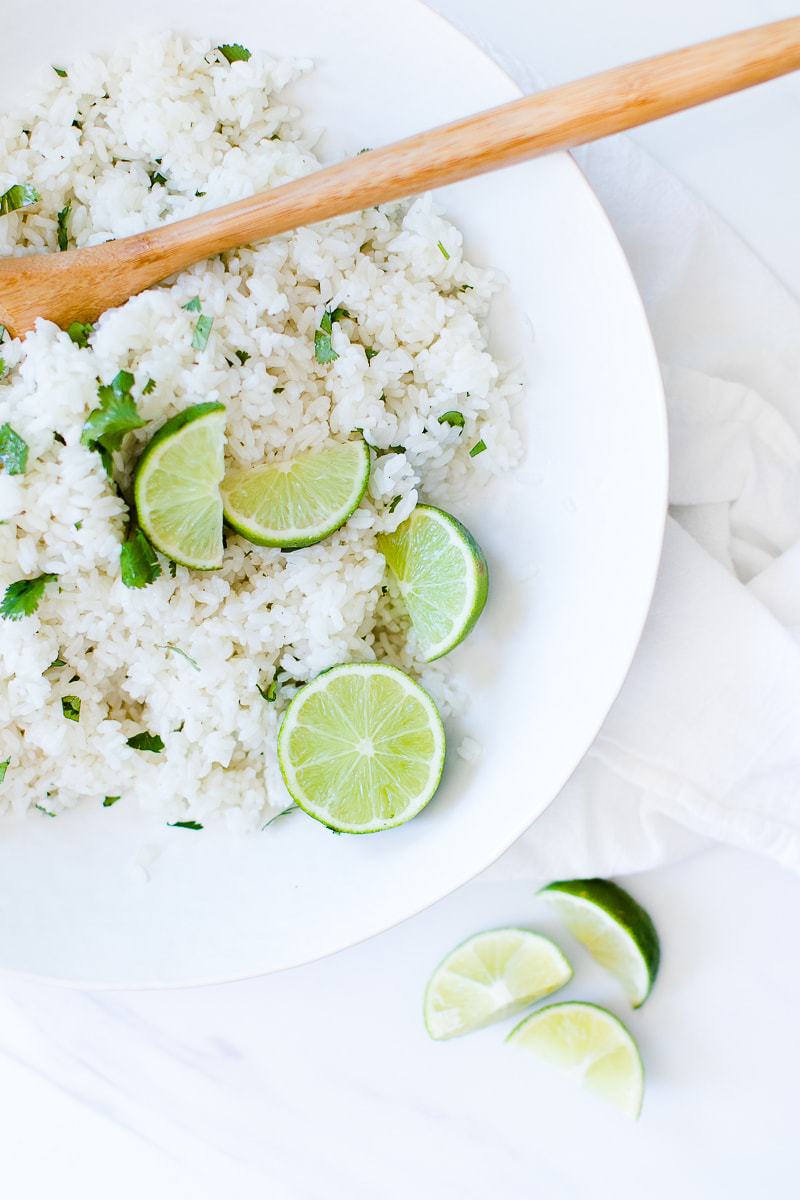 Easy Cilantro Lime Rice in a white bowl with slices of fresh lime