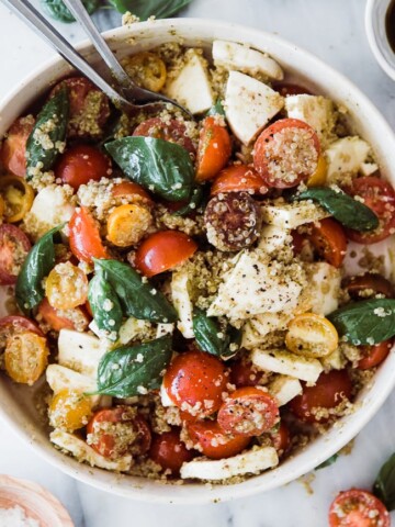 caprese salad and pesto quinoa tossed together in a bowl
