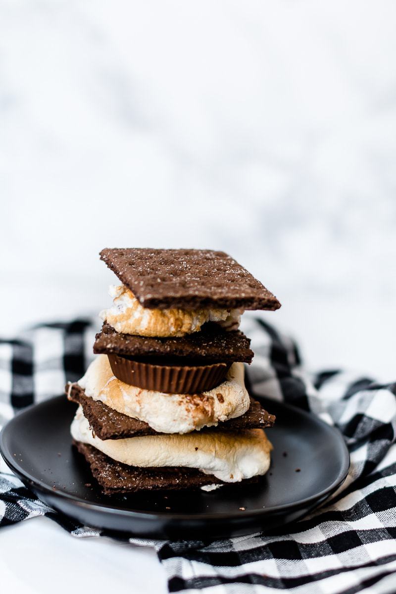 chocolate peanut butter cup s'mores on a black plate