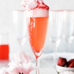 single champaign glass with sparkling strawberry lemonade and cotton candy as garnish on top