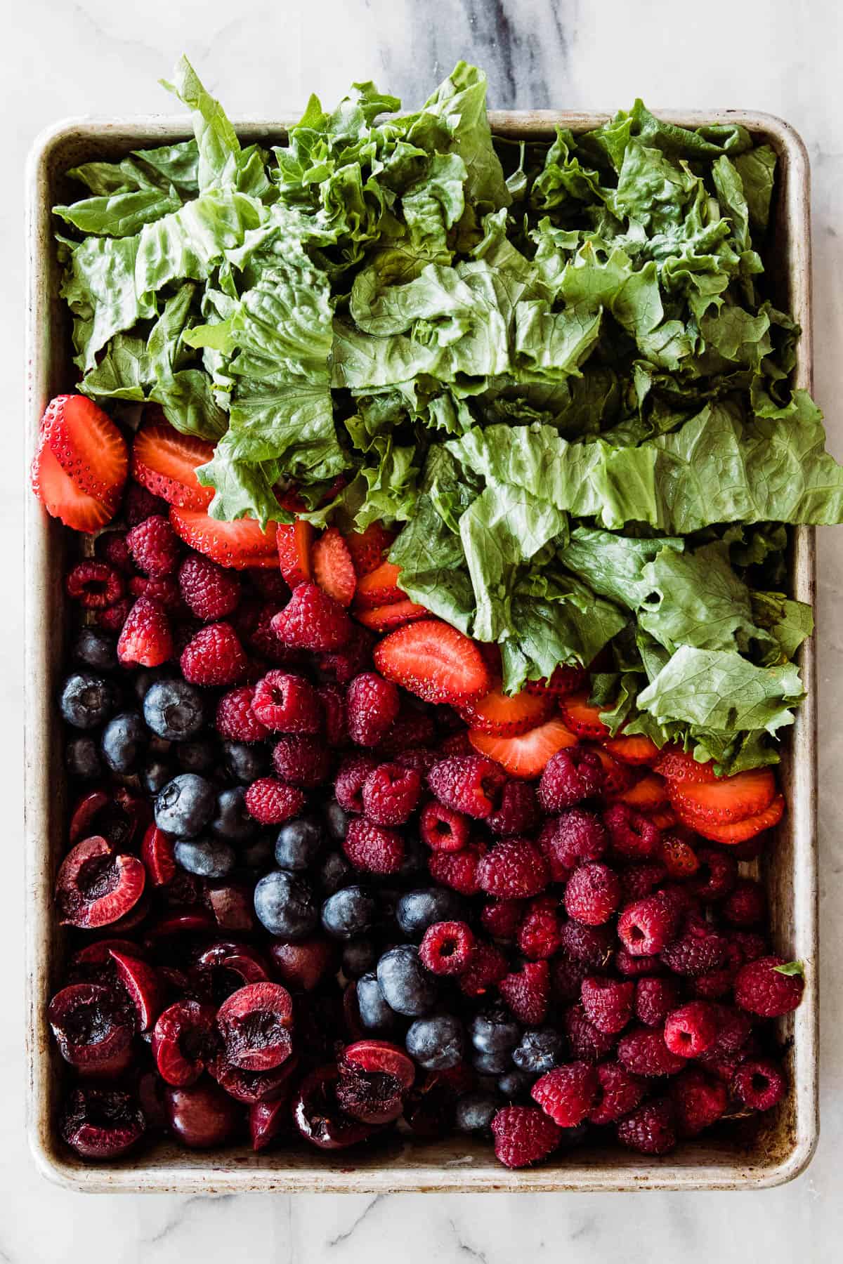 berries, almonds and lettuce on a small cookie sheet. 
