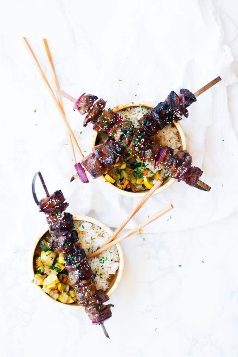 Mongolian BBQ Beef Skewers on top of veggie bowls with rice