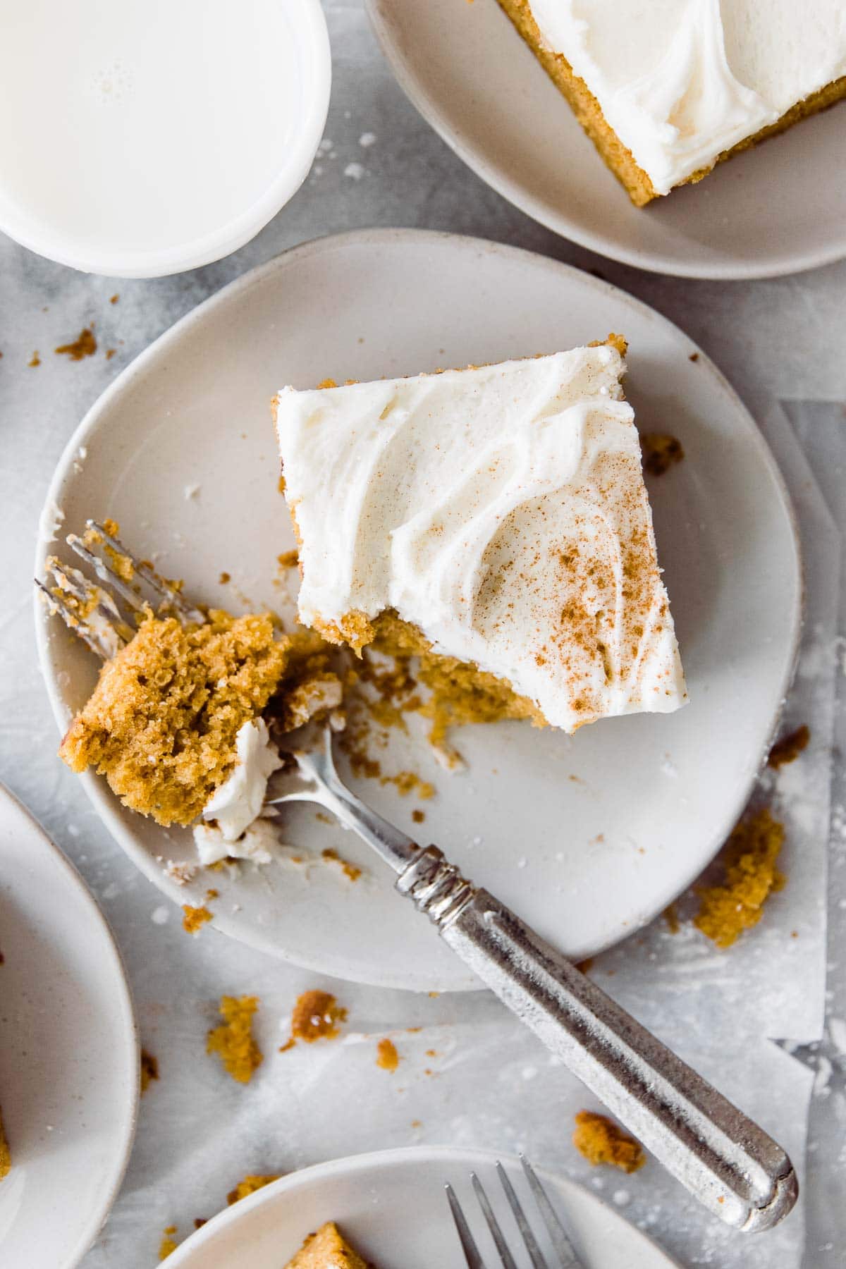 slice of pumpkin cake on a small plate with a fork cutting into it 