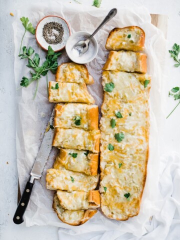 Green chili cheddar bread on a cutting board. Garnished with parsley.