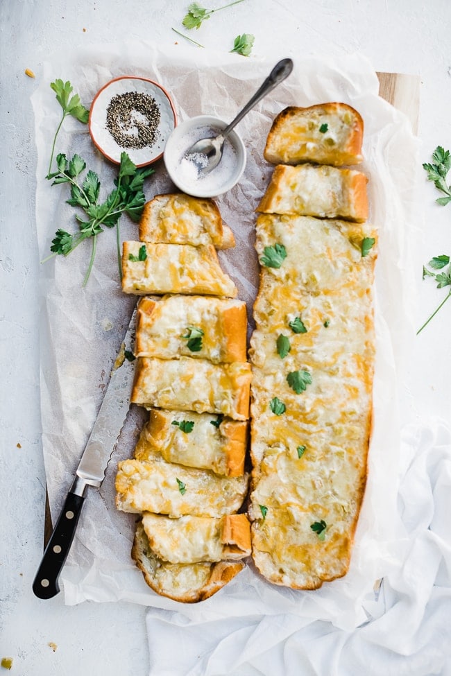 Green chili cheddar bread on a cutting board. Garnished with parsley.