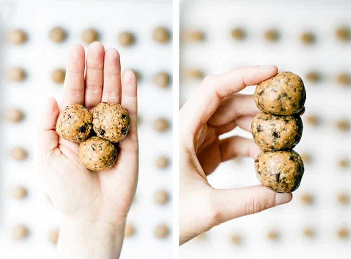 Three peanut butter protein balls in the palm of a hand and then stacked on top of each other and held by a hand.
