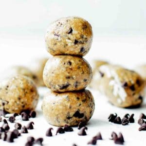A stack of three protein balls for kids on the table with chocolate chips.