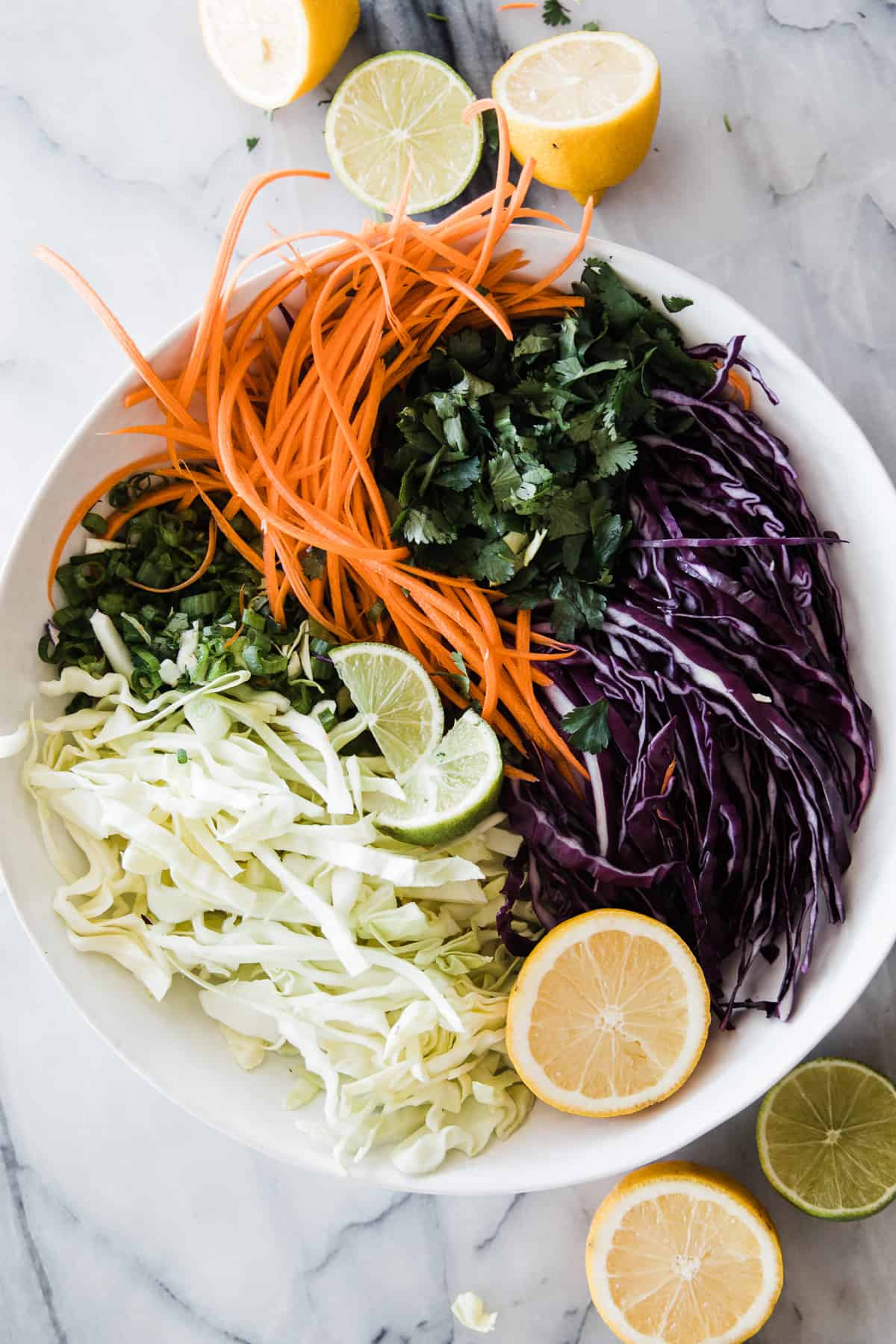 large white bowl with chopped veggies for citrus slaw
