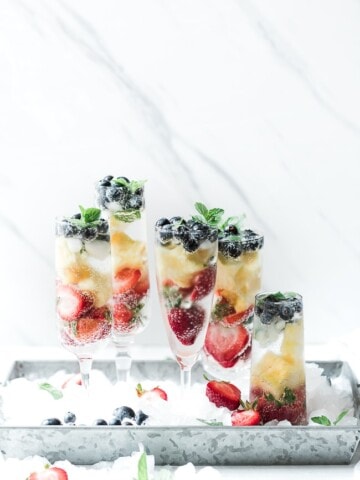 Red white and blueberry summer mocktail in champagne glasses.