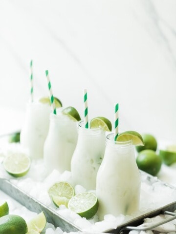 Limeade lined up in milk glasses.