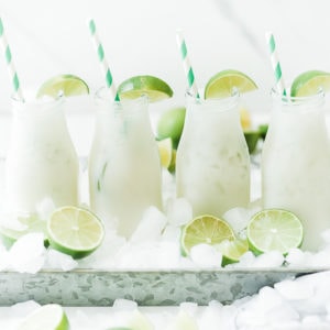Brazilian limeade in milk glasses, garnished with lime.