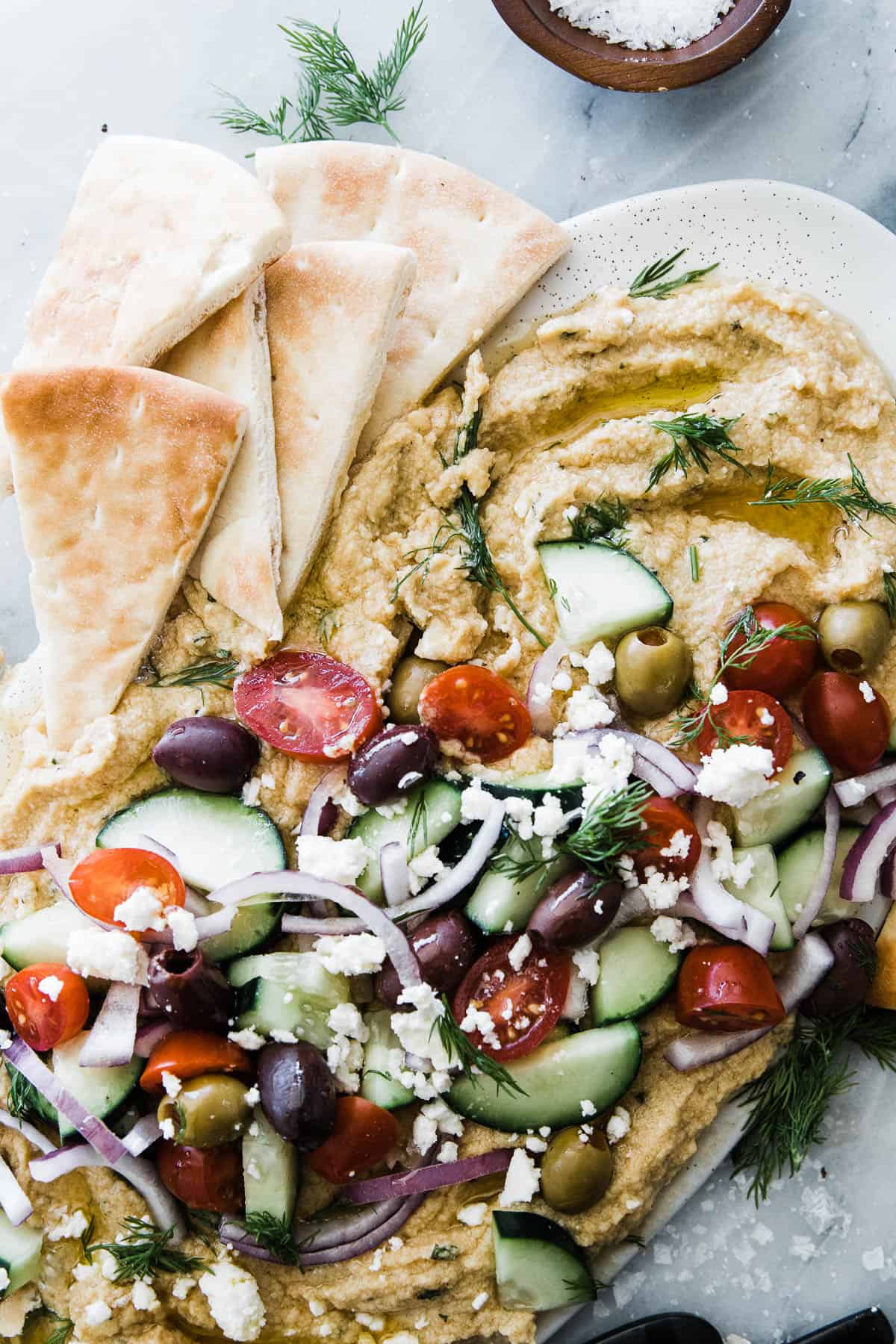 Platter of loaded greek hummus with feta cheese topped. 