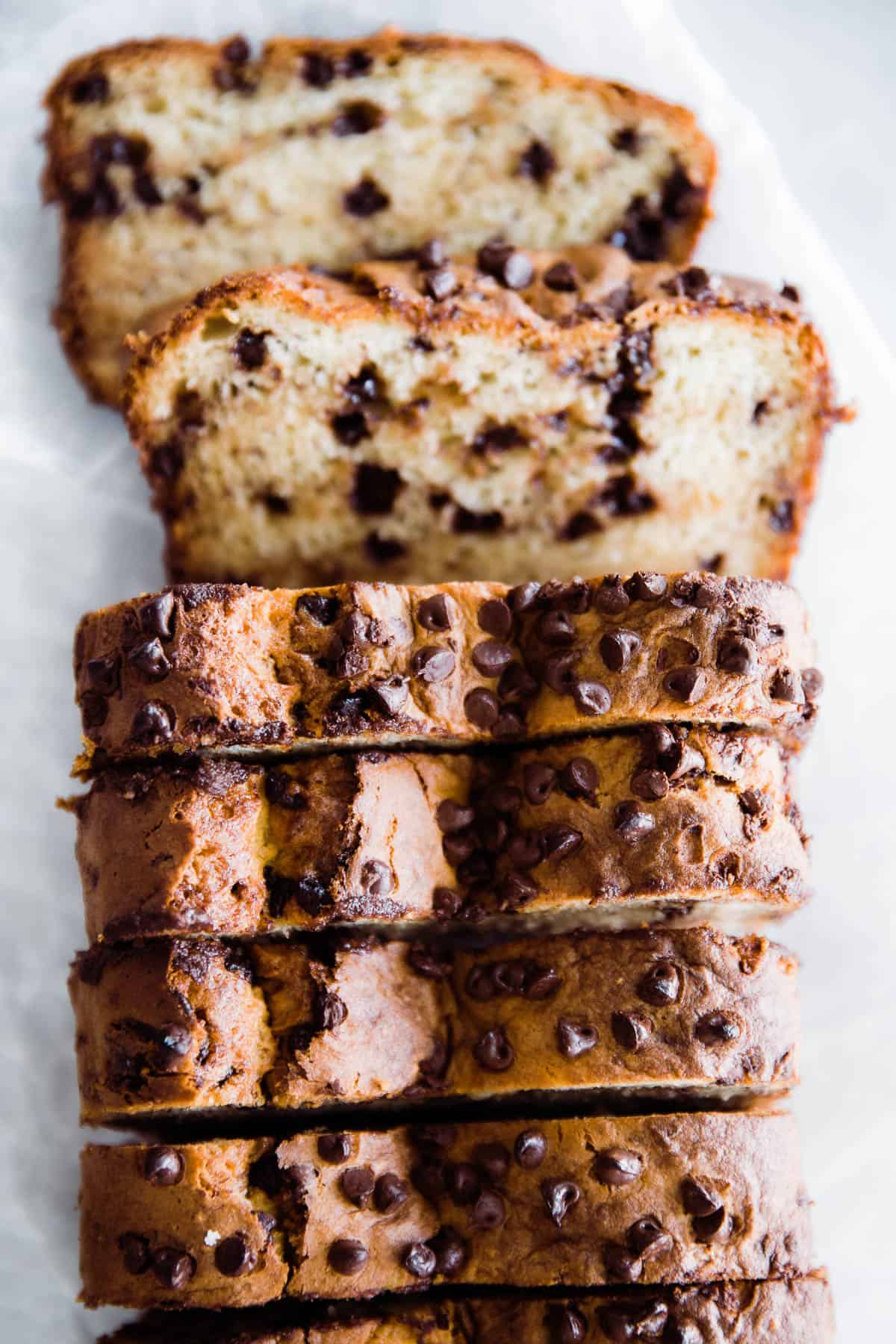 Sliced chocolate chip banana bread with two slices laying down. 
