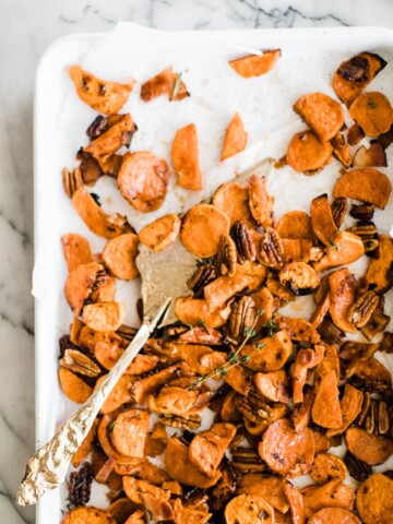 sweet potatoes baked on white baking sheet with cold spatula