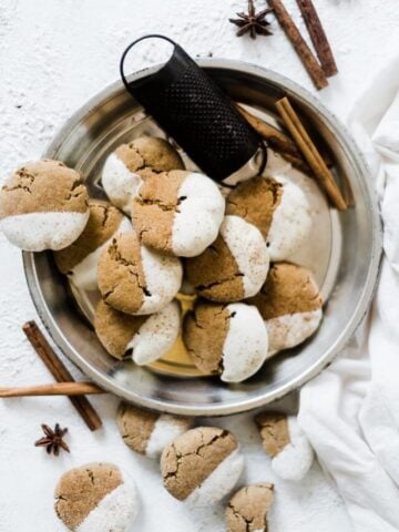 Soft molasses cookies in a pie tin, garnished with cinnamon sticks.