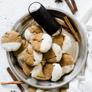 Soft molasses cookies in a pie tin, garnished with cinnamon sticks.