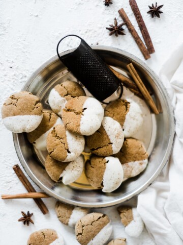 Soft molasses cookies in a pie tin, garnished with cinnamon sticks.