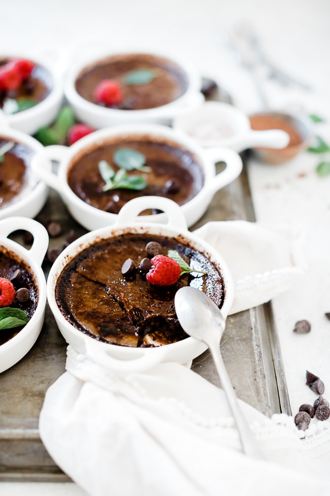 Chocolate creme brulee in white tart dishes, shot from the side.