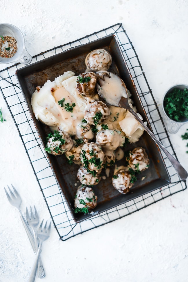 Easy Swedish meatball recipe served atop mashed potatoes.
