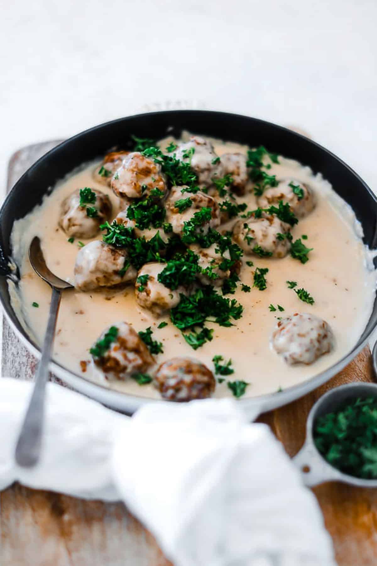 Swedish meatballs in a cast iron skillet, smothered in gravy.