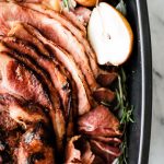 sliced ham in roaster with herbs and pears