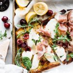 grilled flatbread pizza with arugula, cherries, prosciutto and cherries