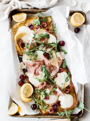 grilled flatbread pizza with arugula, cherries, prosciutto and cherries