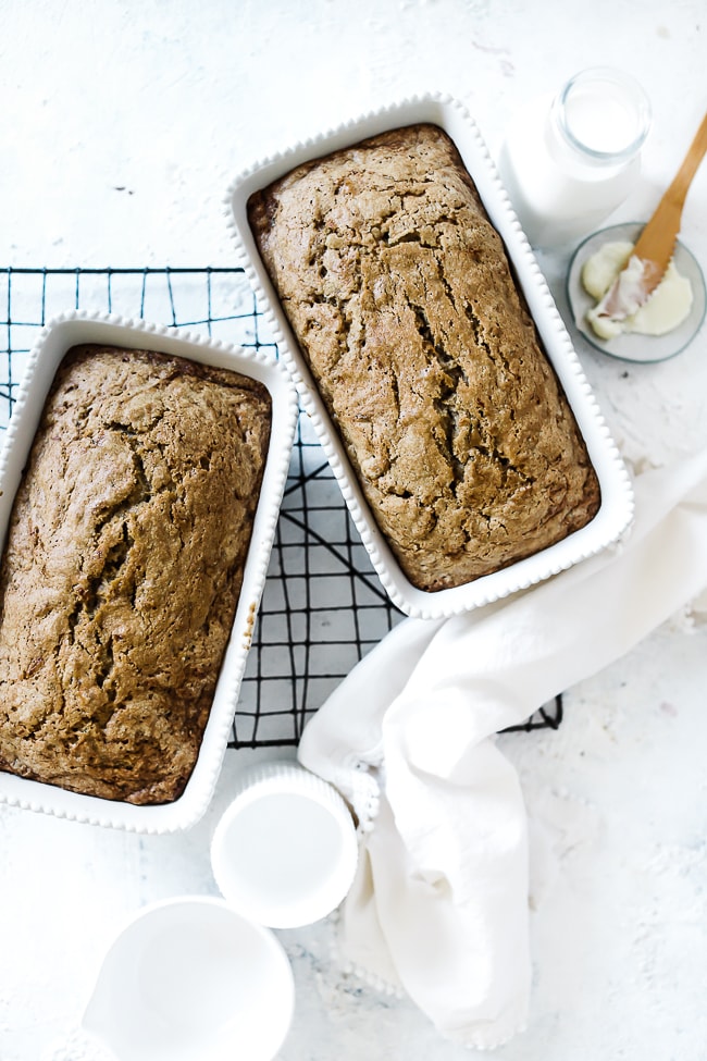 Easy zucchini bread baked in white loaf pans. The pans are atop a cooling rack.