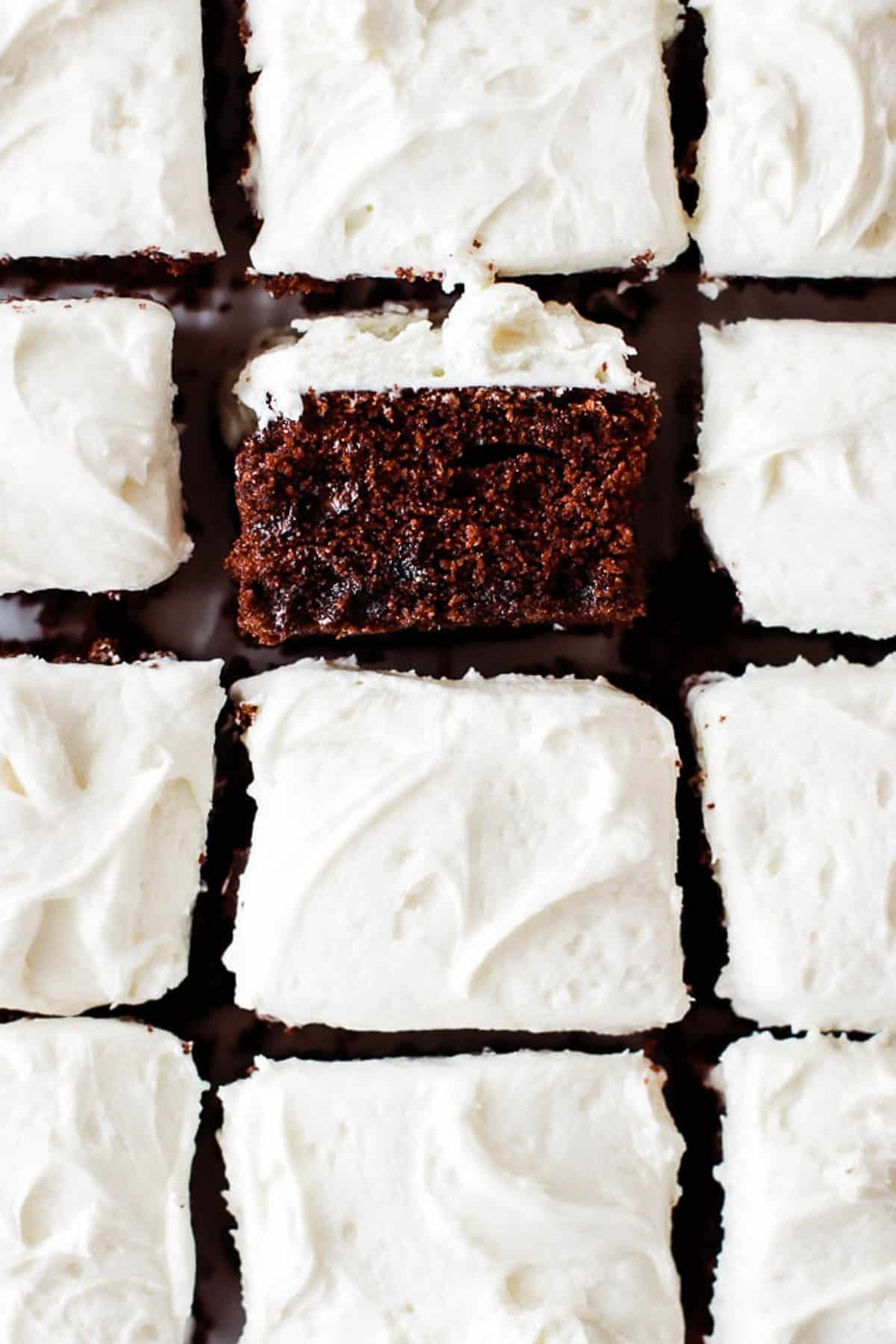 Squares of chocolate zucchini cake with one flipped on its side to show how fluffy and moist the cake is. 