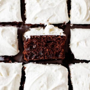 Squares of chocolate zucchini cake with one flipped on its side to show how fluffy and moist the cake is.