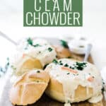 Pin for pinterest graphic with clam chowder in a bread bowl and text on top.