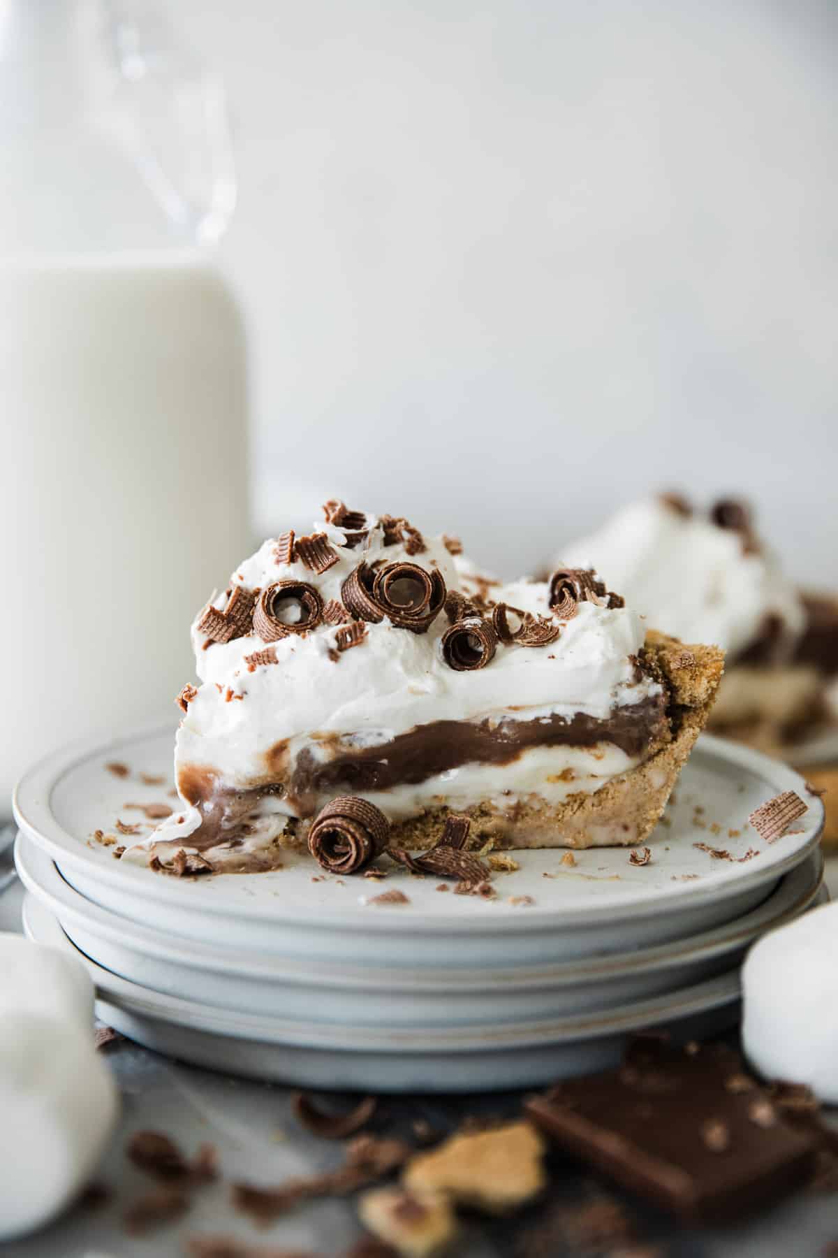 Marshmallow chocolate cream S'mores pie on a stack of plates. 