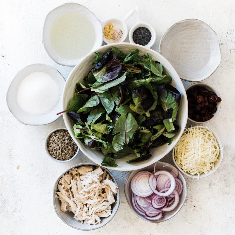 Ingredients needed for leftover turkey recipe salad: lettuce, onion, turkey, dressing, in round bowls.