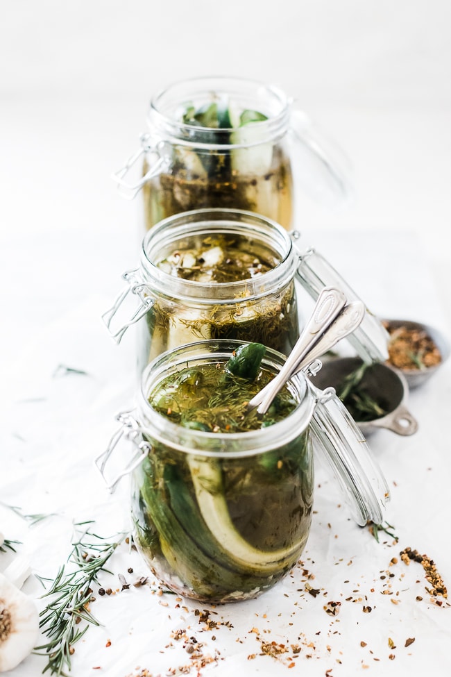 Garlic dill pickle recipe in glass hinged jars. The jars are set in a row.