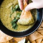 tomatillo salsa verde in bowl with chip dipping