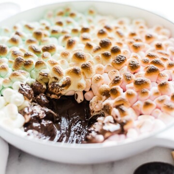 S'mores dip recipe in a white braiser with a large scoop scooped out.
