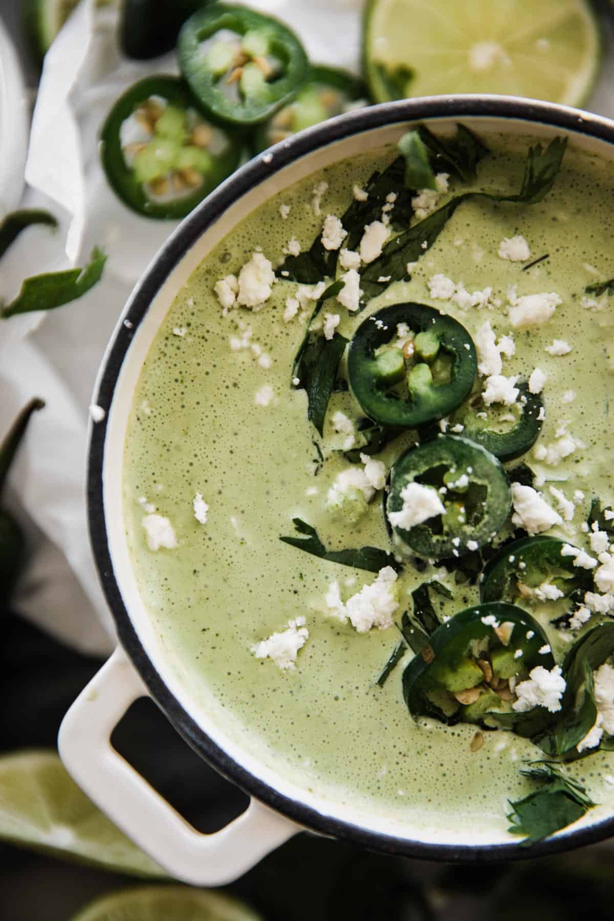Jalapeno sauce in a bowl topped with cilantro, fresh jalapeño and cheese.