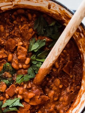 A pot of best baked beans garnished with parsley.