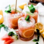 Three glasses of watermelon mint lemonade on the table garnished with fresh mint.