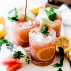 Three glasses of watermelon mint lemonade on the table garnished with fresh mint.