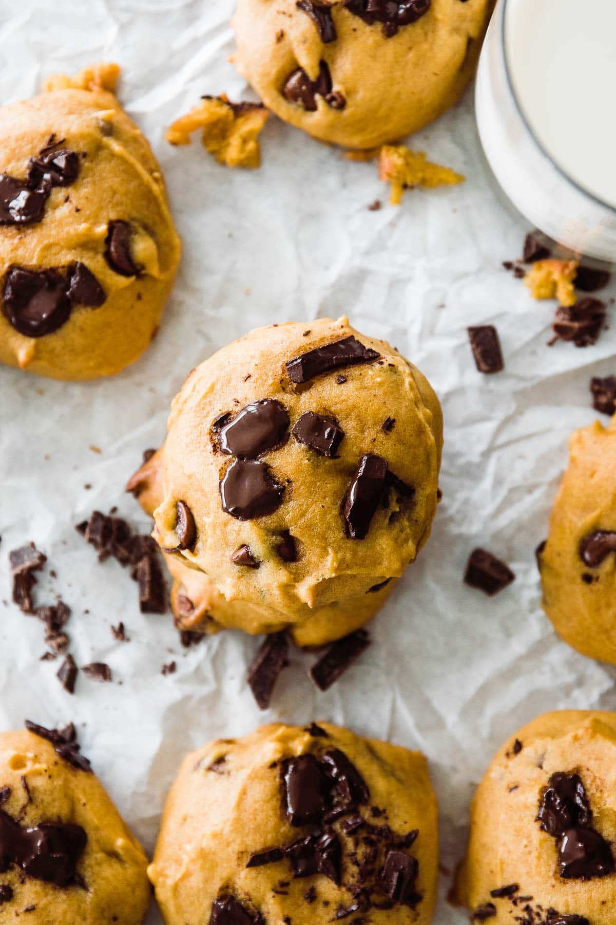 up close shot of a  pumpkin cookie with  a melted  chocolate chip on top. 