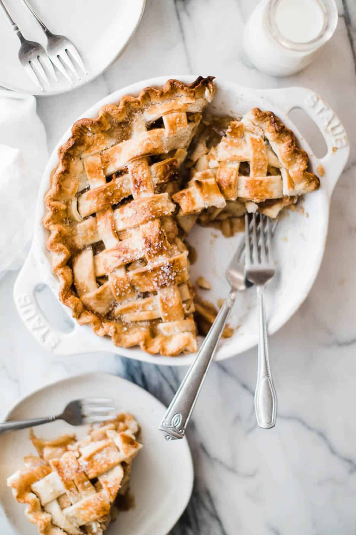 sliced apple pie in a white pie pan